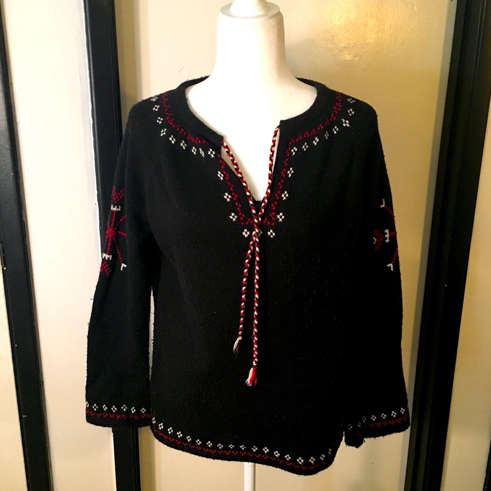 Black bell sleeve sweater with white and and red snowflake designs